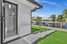 Exterior bathroom featuring a glass-enclosed shower, neutral-toned flooring, and modern fixtures, complemented by a composite dock, a concrete walkway