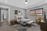 Neutral-toned interior featuring wood-finish flooring, recessed lighting, a modern spherical ceiling fixture, and a large horizontal window with a bla