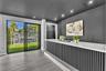 Built-in bar featuring a stone-surface countertop, slatted wood-finish base, recessed ceiling lighting, and sliding glass doors with water and landsca