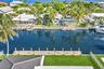 Waterfront property featuring a private boat dock, bulkheaded seawall, and manicured lawn