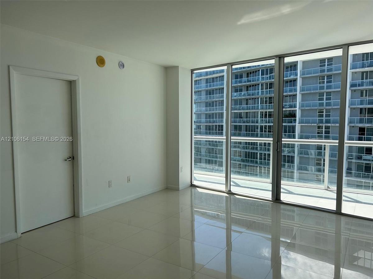 Floor-to-ceiling glass paneling and polished tile flooring