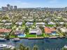 Waterfront property featuring a private bulkhead, deep-water access, expansive lawn, and mature palm trees