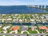 Aerial perspective of waterfront properties featuring deep-water canal access, private boat docks, and manicured landscaping