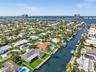 Waterfront property featuring direct canal access, a private dock, a swimming pool, and manicured landscaping
