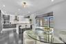 Contemporary kitchen featuring two-toned cabinetry, quartz countertops with full-height backsplash, stainless steel appliances, a tiered center island