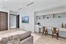 Built-in light-tone cabinetry with open shelving, integrated desk workspace, wood-finish flooring, recessed lighting, and solid-core doors
