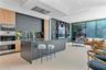 Custom kitchen featuring dual-tone cabinetry, a large center island, floor-to-ceiling glass sliding doors, and built-in shelving