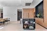 Modern kitchen featuring wood-finish cabinetry, matte black integrated shelving, a central island with storage, built-in wall appliances, and tile flo