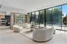 Floor-to-ceiling sliding glass doors, integrated custom shelving unit with glass-front cabinetry, large-format tile flooring, recessed lighting, and b