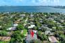 Aerial perspective featuring mature trees, landscaped grounds, and proximity to the waterfront