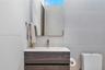 Floating vanity with a wood-finish, dual-drawer cabinet, crisp white countertop, integrated sink, and modern polished metal faucet, complemented by a 