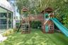 Outdoor area featuring low-maintenance synthetic turf, integrated wood play structure with dual towers and slide, and established perimeter privacy he