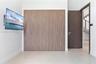 Floor-to-ceiling wood-finish cabinetry, solid-core interior door with brushed metal hardware, and large-format tile flooring