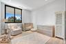 Room featuring light wood-finish flooring, large black-framed windows, and recessed ceiling lighting