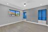 Room featuring wood-finish flooring, recessed lighting, horizontal window with black trim, and dual built-in floor-to-ceiling cabinets with glass door