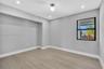 Neutral-toned room featuring wood-finish flooring, recessed lighting, a modern globe-style ceiling fixture, and a built-in recessed wall alcove