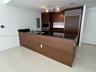 Kitchen featuring dark wood-finish cabinetry, black stone countertops, integrated stainless steel refrigerator, stainless steel built-in microwave and