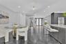 Open-concept interior featuring high-gloss polished flooring, recessed lighting, a modern kitchen island with vertical slat detailing, and a multi-pan