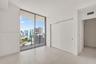 Floor-to-ceiling windows, private balcony with metal and glass railing, large-format tile flooring, and built-in sliding door closet