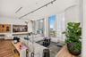 Floor-to-ceiling glass paneling, wood-finish flooring, floating wall-mounted shelving, and architectural track lighting