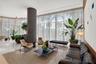 Floor-to-ceiling glass walls, expansive polished stone flooring, central structural pillar with smooth matte finish, and integrated recessed lighting
