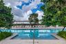 Swimming pool featuring a tiled deck, built-in steps, and a pergola-covered patio area