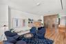 Wood-finish flooring, custom built-in cabinetry with integrated shelving, and vertical wood-slat room divider