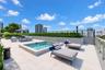 Rooftop terrace featuring a built-in spa, expansive tile decking, a metal railing, and integrated privacy hedging