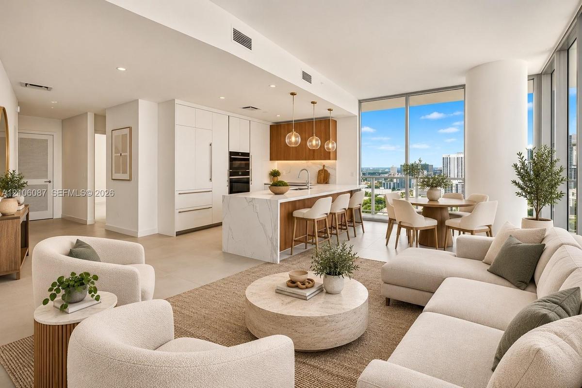 Open-concept kitchen featuring an island with a stone countertop, floor-to-ceiling windows, custom cabinetry, built-in stainless steel double ovens, a