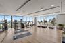 Fitness area featuring floor-to-ceiling windows, wood-finish flooring, mirrored walls, recessed lighting, and a cylindrical structural column