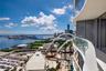 Curved balcony with glass panel railing, tile flooring, and full-height sliding glass doors