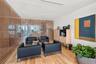 Interior space featuring a floor-to-ceiling slatted wood screen, light-toned wood-finish flooring, and recessed ceiling lighting