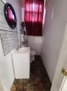 Half bath featuring vanity, stone finish floors, and tasteful backsplash