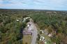 Aerial view of property and surrounding area featuring a forest