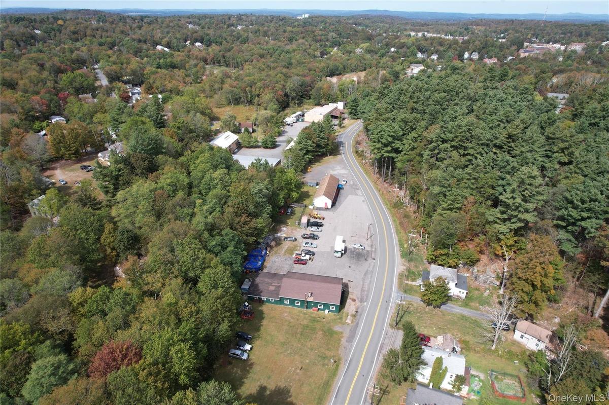 Aerial view of property and surrounding area featuring a forest