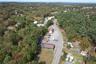 Aerial view of property and surrounding area featuring a forest