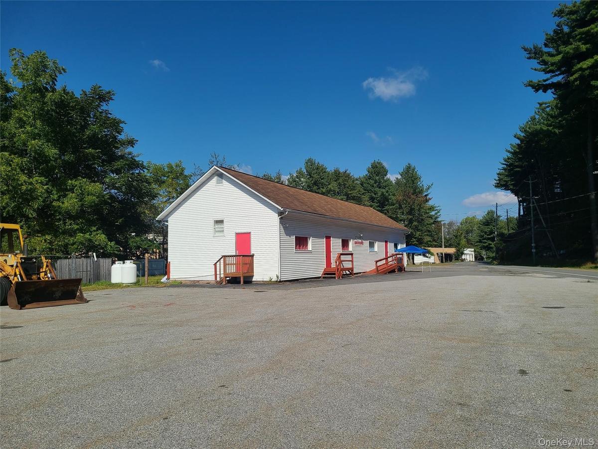 View of side of property with roof with shingles