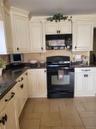 Cream-painted cabinetry with decorative crown molding and dark hardware