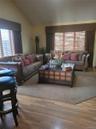 Vaulted ceiling, wood-finish flooring, and multiple window treatments