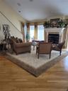 Wood-finish flooring, recessed lighting, and a fireplace with a stone surround and ornate mantel