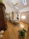 Vaulted ceiling with skylight, wood-finish flooring, ceiling fan, and built-in closet with bifold doors