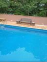 In-ground swimming pool with light blue patterned liner and stainless steel entry ladder