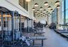 Fitness center featuring a high ceiling, extensive natural light from floor-to-ceiling windows, numerous pendant light fixtures, and varied exercise e