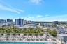 Expansive outdoor pool area featuring multiple lounge chairs, shaded cabanas, and umbrellas