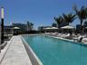 Expansive outdoor pool with integrated lighting and surrounding lounge chairs under umbrellas