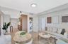 Open-concept living area with wood-finish flooring, recessed lighting, and a built-in stacked washer and dryer