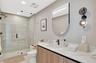 Glass-enclosed shower with large format tile surround