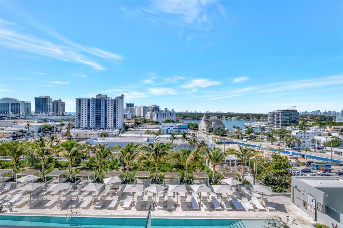 Expansive outdoor pool area featuring multiple lounge chairs, shaded cabanas, and umbrellas