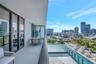 Covered terrace featuring floor-to-ceiling glass sliding doors, dark metal railings, and concrete flooring