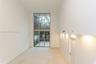 Double-height ceilings, expansive floor-to-ceiling windows, light-toned stone flooring, and integrated recessed wall lighting